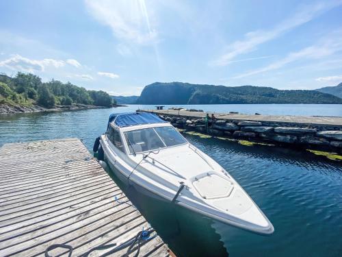 a boat is docked at a dock on a river at Holiday Home Sjøtun by Interhome in Hyllestad