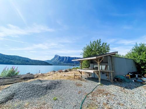 a shed sitting on the side of a lake at Holiday Home Sjøtun by Interhome in Hyllestad