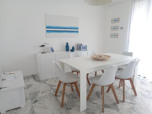 a white dining room with a table and chairs at Anna e il mare in Cogoleto