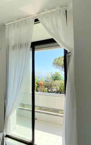 a window with white curtains in a room at Anna e il mare in Cogoleto