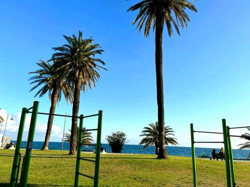 a park with palm trees and a volley ball hoop at Anna e il mare in Cogoleto