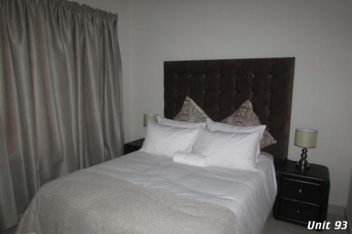 a bedroom with a bed with white sheets and pillows at Pendleberry Grove Holidays in Bela-Bela