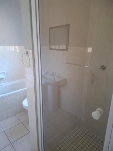 a bathroom with a shower and a sink at Pendleberry Grove Holidays in Bela-Bela