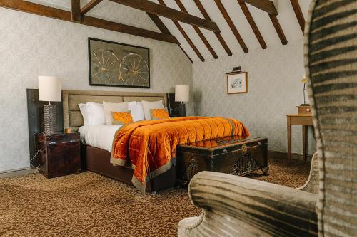 a bedroom with a bed with an orange blanket at South Lodge in Lower Beeding