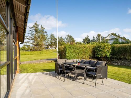 a patio with a table and chairs in a yard at Holiday Home Vicente - 800m from the sea in NW Jutland by Interhome in Hanstholm