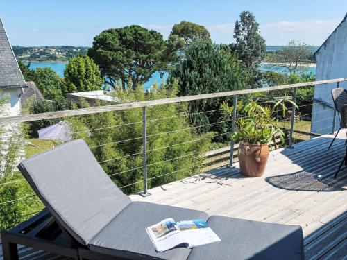 a deck with a chair and a book on it at Holiday Home La Bellevue de Pen Ar Rhun by Interhome in Locquirec