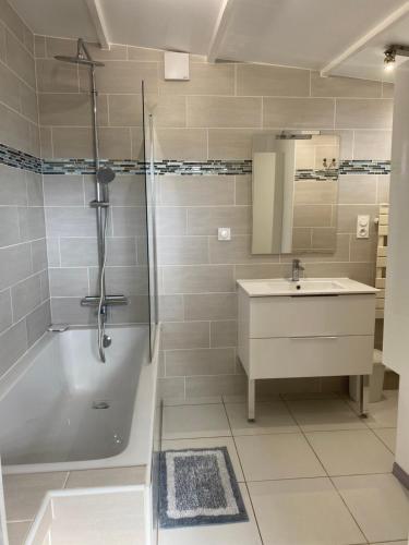 a bathroom with a tub and a sink and a shower at Maison de campagne in Beuzeville-la-Guérard