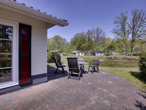a patio with chairs and a table next to a house at Holiday Home 4-persoons bos-2 by Interhome in Dalfsen
