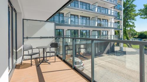 a balcony with a table and chairs in front of a building at Apartamenty Helski Brzeg in Hel
