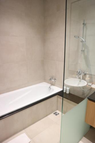 a bathroom with a bath tub and a sink at Treehouse Suites - Boutique Serviced Apartment in Jakarta