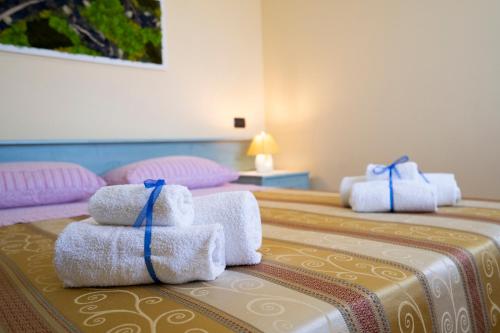 two beds with towels sitting on top of them at Casa Fiore in Torre Marino