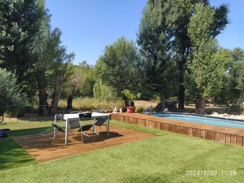 - une table et des chaises dans une cour à côté de la piscine dans l'établissement Maison nature, à Le Val