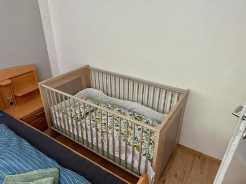 a crib in a room with a bed at Wohlfühlen im Zuhause auf Zeit in Wildon
