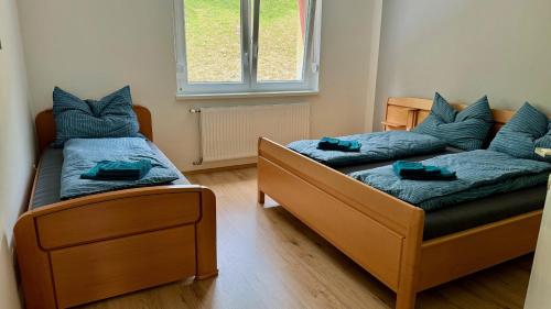 two beds in a small room with a couch at Wohlfühlen im Zuhause auf Zeit in Wildon