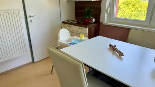 a room with a white table and chairs and a window at Wohlfühlen im Zuhause auf Zeit in Wildon