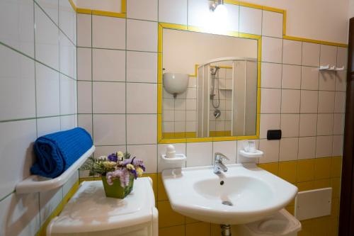 a bathroom with a sink and a mirror and a toilet at Casa Fiore in Torre Marino