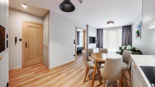 a kitchen and dining room with a table and chairs at Apartamenty Helski Brzeg in Hel