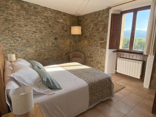 a bedroom with a bed and a stone wall at Fonda dels Pics in Escardacs