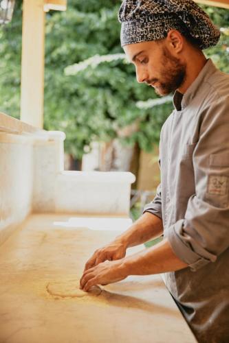 a man in a hat kneading a piece of wood at Castello di Baccaresca in Branca