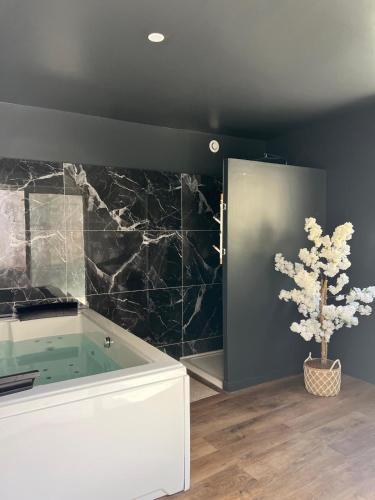La salle de bains est pourvue d'une baignoire avec un arbre. dans l'établissement Les Loges des Coteaux - Loge 1 - Luxury lodges with jacuzzi, à Blaye