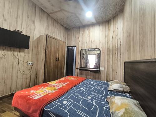 a bedroom with a bed in a wooden wall at HOTEL JOGI GUEST HOUSE welcome all families, friends, groups, couples, singles fully Airconditioner, attach washrooms, lift, wifi, 24 hours room service, power backup in Amritsar