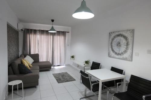a living room with a couch and a table at Near the Beach Holiday Apartment in Limassol