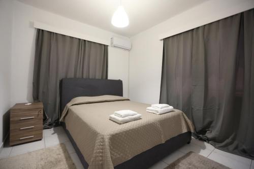 a bedroom with a bed with two towels on it at Near the Beach Holiday Apartment in Limassol