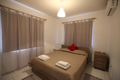 a bedroom with two beds with towels on them at Near the Beach Holiday Apartment in Limassol