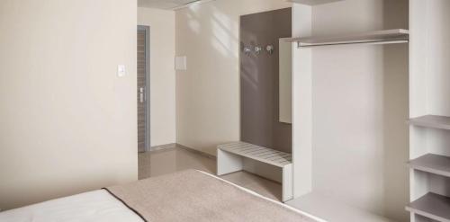 a bedroom with a walk in shower and a closet at Hotel & Wellness Stella Delle Langhe in Govone