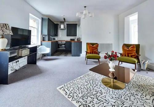 a living room with a couch and chairs and a table at Countryside bliss in Historic Hall in Burton Overy