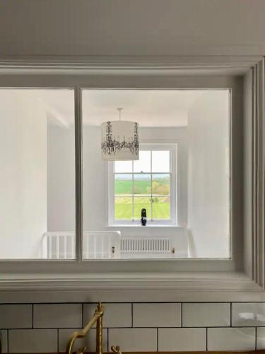 a window in a white kitchen with a sink at Countryside bliss in Historic Hall in Burton Overy