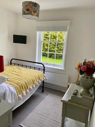 a bedroom with a bed and a window at Countryside bliss in Historic Hall in Burton Overy