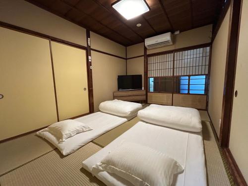 a room with three beds and a tv in it at 富山県美術館裏の和風宿Hide-inn 隠れ家T #HH8 in Toyama