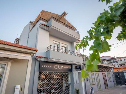 a white building with a balcony on top of it at Ten Suns Downtown A by 8essentially in Lixouri