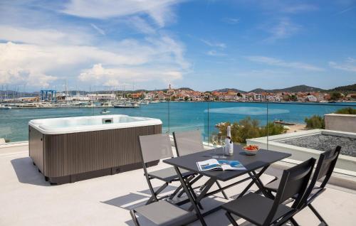 eine Terrasse mit einem Tisch und einer Badewanne in der Unterkunft Amazing Apartment In Betina in Betina