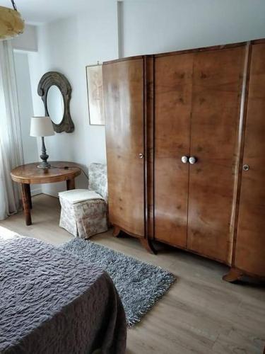 - une chambre avec une grande armoire en bois et une table dans l'établissement Studio Cosy proche Strasbourg, à Hoenheim