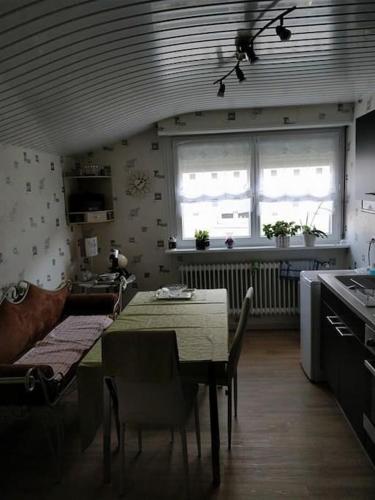 une cuisine avec une table et des chaises ainsi qu'une fenêtre dans l'établissement Studio Cosy proche Strasbourg, à Hoenheim