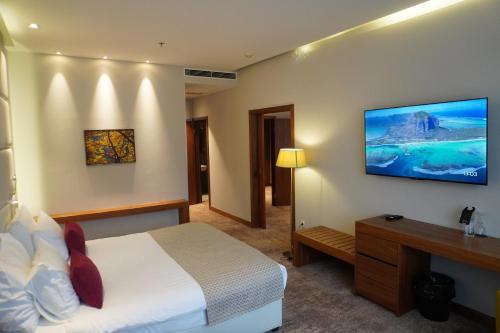 a hotel room with a bed and a television on the wall at Hotel Mepas in Mostar
