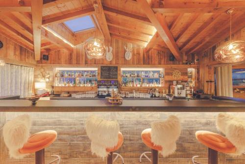 a bar with orange stools in a wooden restaurant at La Clef des Champs in Morzine