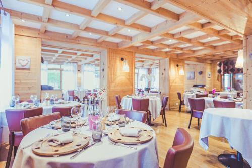 a dining room with white tables and chairs at La Clef des Champs in Morzine