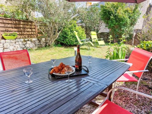 - une table de pique-nique avec une bouteille de vin et une assiette de nourriture dans l'établissement Holiday Home Ty Marieflo by Interhome, à Ploemeur