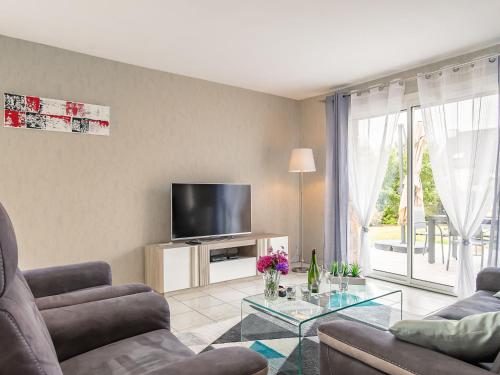 un salon avec un canapé et une télévision dans l'établissement Holiday Home Les Camélias by Interhome, à Perros-Guirec