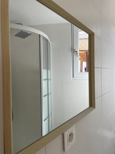 un miroir sur le mur d'une salle de bains dans l'établissement Dépendance 3 pièces Toulon, à Toulon