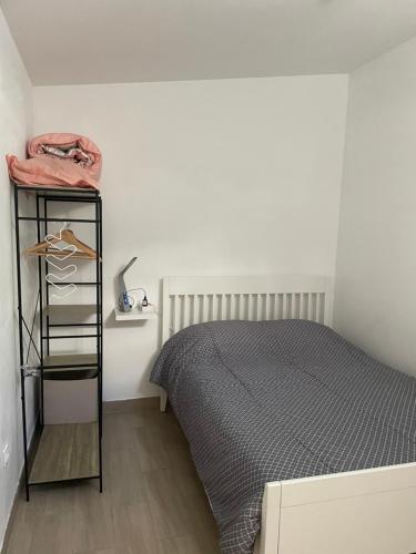 - une chambre avec un lit et une étagère à côté dans l'établissement Dépendance 3 pièces Toulon, à Toulon
