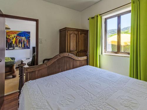 a bedroom with a bed with green curtains and a window at Holiday Home Do Condado by Interhome in Caminha