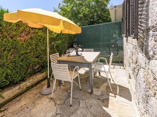 a table and chairs with an umbrella on a patio at Holiday Home Do Condado by Interhome in Caminha