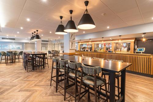 a restaurant with tables and chairs and a bar at Sedgebrook Hall in Northampton