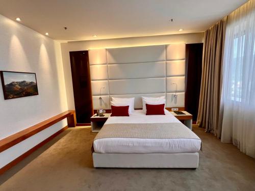 a bedroom with a large bed with red pillows at Hotel Mepas in Mostar