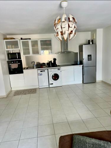  La cuisine est équipée de placards blancs et d'un réfrigérateur. dans l'établissement Location appartement T3, à Marseille