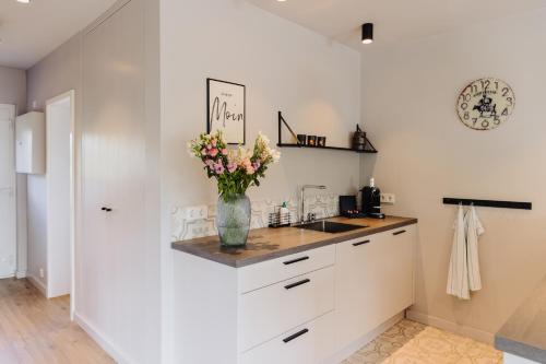 a kitchen with a vase of flowers on a counter at Seetiid in Westerland (Sylt)